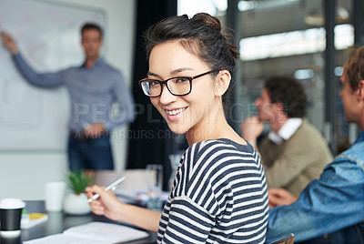 Buy stock photo Portrait of an office worker sitting in a meeting with her colleagues in the background