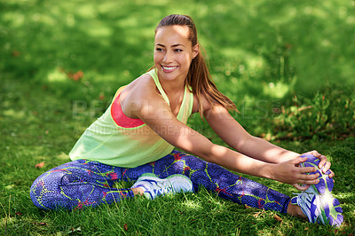 Buy stock photo Shot of a young woman stretching her legs before a workout