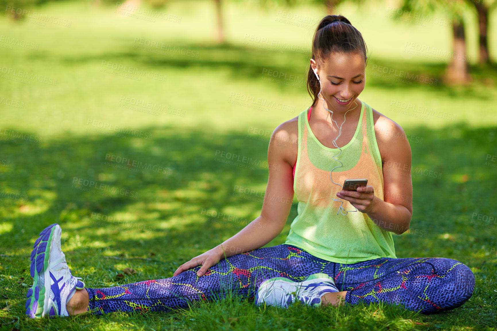 Buy stock photo Outdoor, phone and smile of woman, stretching and music in grass of park, fitness and sportswear. Nature, streaming and girl with earphones in morning, exercise and training with wellness and happy