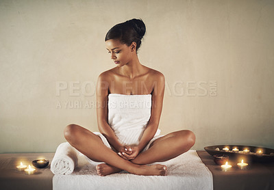 Buy stock photo Full length shot of a young woman sitting on a massage table at the spa