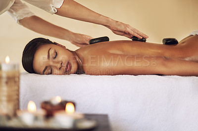 Buy stock photo Back massage, hot stone and relax with woman in spa for health, skincare or stress relief on bed. Beauty, peace and wellness with customer person at luxury resort for natural treatment or recovery