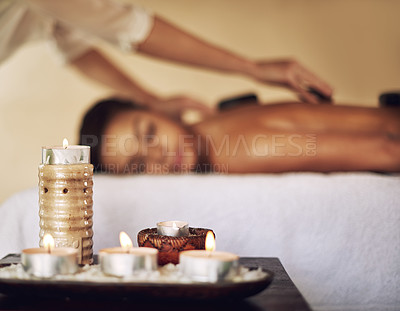 Buy stock photo Candles, hot stones and wax light at a spa for lomi lomi massage, healing or luxury treatment therapy. Health, aromatherapy and wellness products for calm, zen or peaceful atmosphere at natural salon