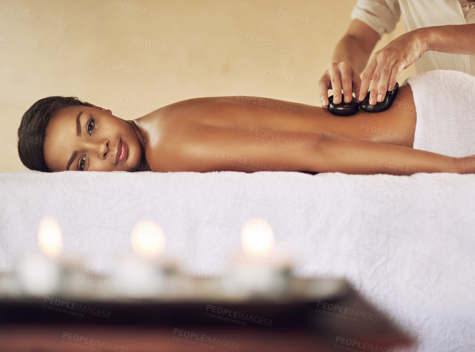 Buy stock photo Back massage, hot stone and portrait with woman in spa for health, skincare or stress relief on bed. Aromatherapy, beauty and smile with customer at luxury resort for natural treatment or recovery