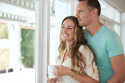 Buy stock photo Happy couple, view and coffee in house with love, romantic and thinking with care in marriage. Man, woman and pride in modern home on weekend, window and bonding together with warm drink to relax