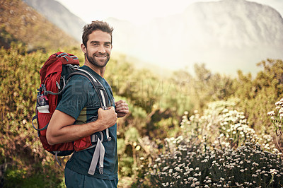 Buy stock photo Shot of a young man enjoying a hike through the mountains