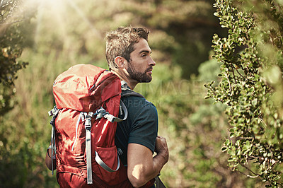 Buy stock photo Shot of a young man hiking along a nature trail