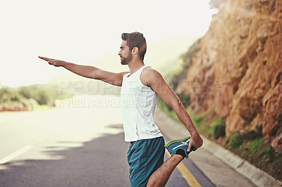 Buy stock photo Shot of a young man stretching before going for a run