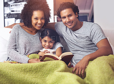 Buy stock photo Child, reading book and family portrait in a home for story time on a lounge sofa with mom and dad. A woman, man and girl child together for development, learning and love with a fantasy or fairytale