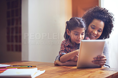 Buy stock photo Shot of a mother and daughter using a digital tablet together at home