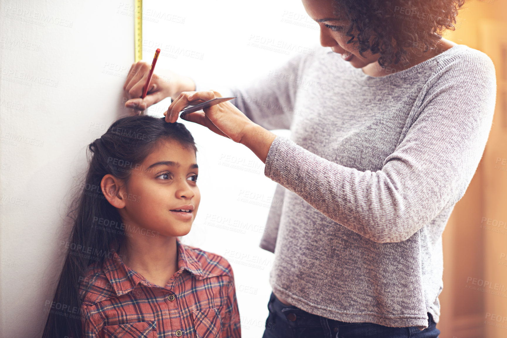 Buy stock photo Mother, child and measuring height with ruler at wall for growth development in home for childhood, love or bonding. Female person, daughter and pencil in apartment for size checking, youth or parent