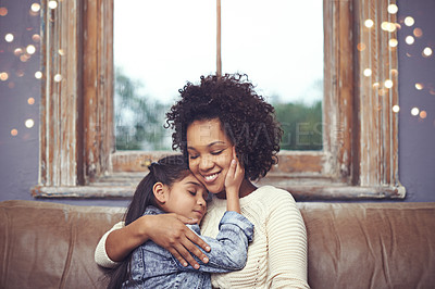 Buy stock photo Shot of a loving mother and daughter sitting on the sofa at home
