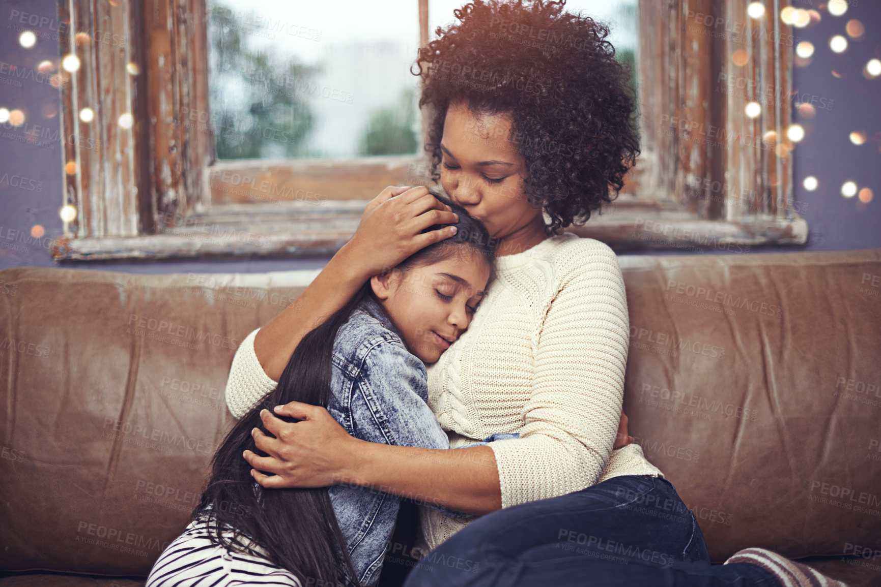 Buy stock photo Shot of a loving mother and daughter sitting on the sofa at home