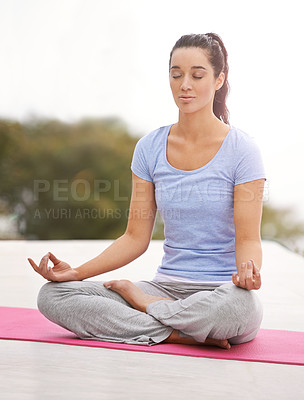 Buy stock photo Full length shot of a young woman doing yoga outdoors
