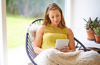 Buy stock photo Tablet, woman and typing in a home with ebook app, blog and reading a social media post on break. Happy, living room and tech for online article in the morning on the internet and website for news