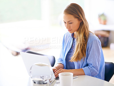 Buy stock photo Shot of a young woman using her laptop at home