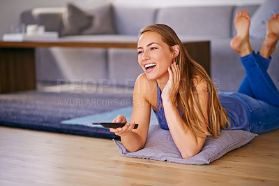 Buy stock photo Shot of a young woman watching television at home