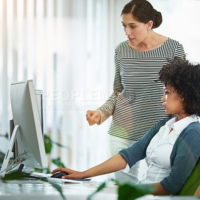 Buy stock photo A training manager talking about online collaboration project with intern assistant looking on a desktop monitor screen. Business woman discussing latest social media strategy or analyzing seo trends