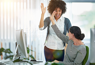Buy stock photo Shot of designers hi-fiving together at a workstation in an office