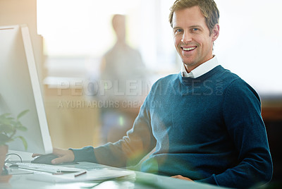 Buy stock photo Portrait of a happy, excited and smiling businessman working on computer at work. Cheerful executive professional with a smile sitting at desktop in modern casual office with colleague in the back. 
