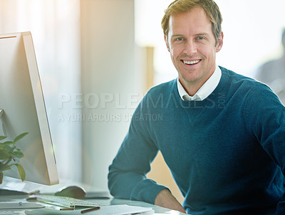 Buy stock photo Happy, confident and smiling businessman sitting at his desk and feeling satisfied with his career and job choice. Portrait of a motivated and proud male entrepreneur working to grow his startup