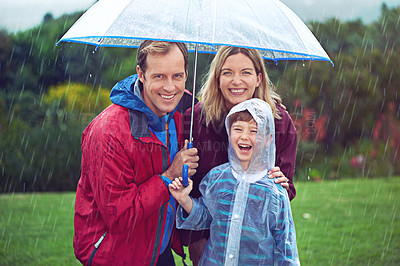 Buy stock photo Happy family, child and portrait in rain with umbrella in nature outdoor for fun, happiness and quality time. Man, woman and boy kid laughing for water drops or freedom while playing in winter