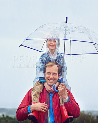 Buy stock photo Cropped portrait of a father carrying his son on his shoulders outside in the rain