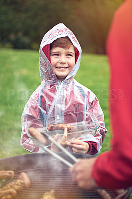 Buy stock photo Shot of a little boy helping his father who's cooking meat on a barbecue grill