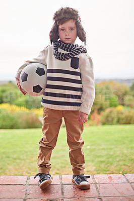 Buy stock photo Shot of a little boy standing outside with his soccer ball
