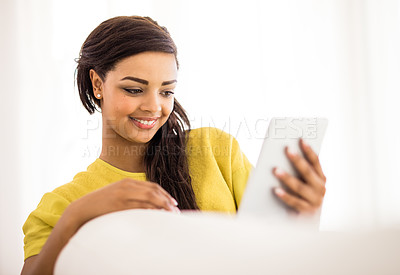 Buy stock photo Shot of a young woman using a digital tablet at home