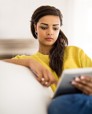 Buy stock photo Shot of a young woman using a digital tablet at home