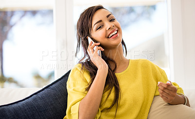 Buy stock photo Shot of a young woman talking on her cellphone at home