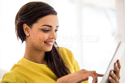 Buy stock photo Shot of a young woman using a digital tablet at home