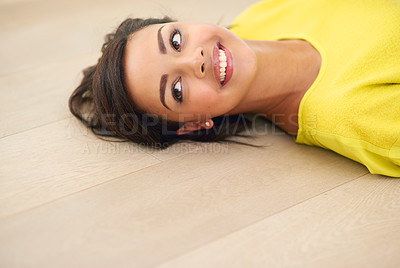 Buy stock photo Cropped shot of a young woman lying on a wooden floor