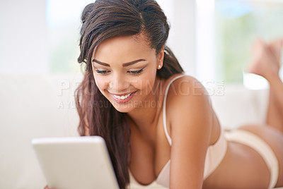 Buy stock photo Black woman, tablet and relax on sofa in lingerie for comfort or leisure, sexy and texting naughty message. Female person, home and online on internet for shopping underwear, happiness and browsing.