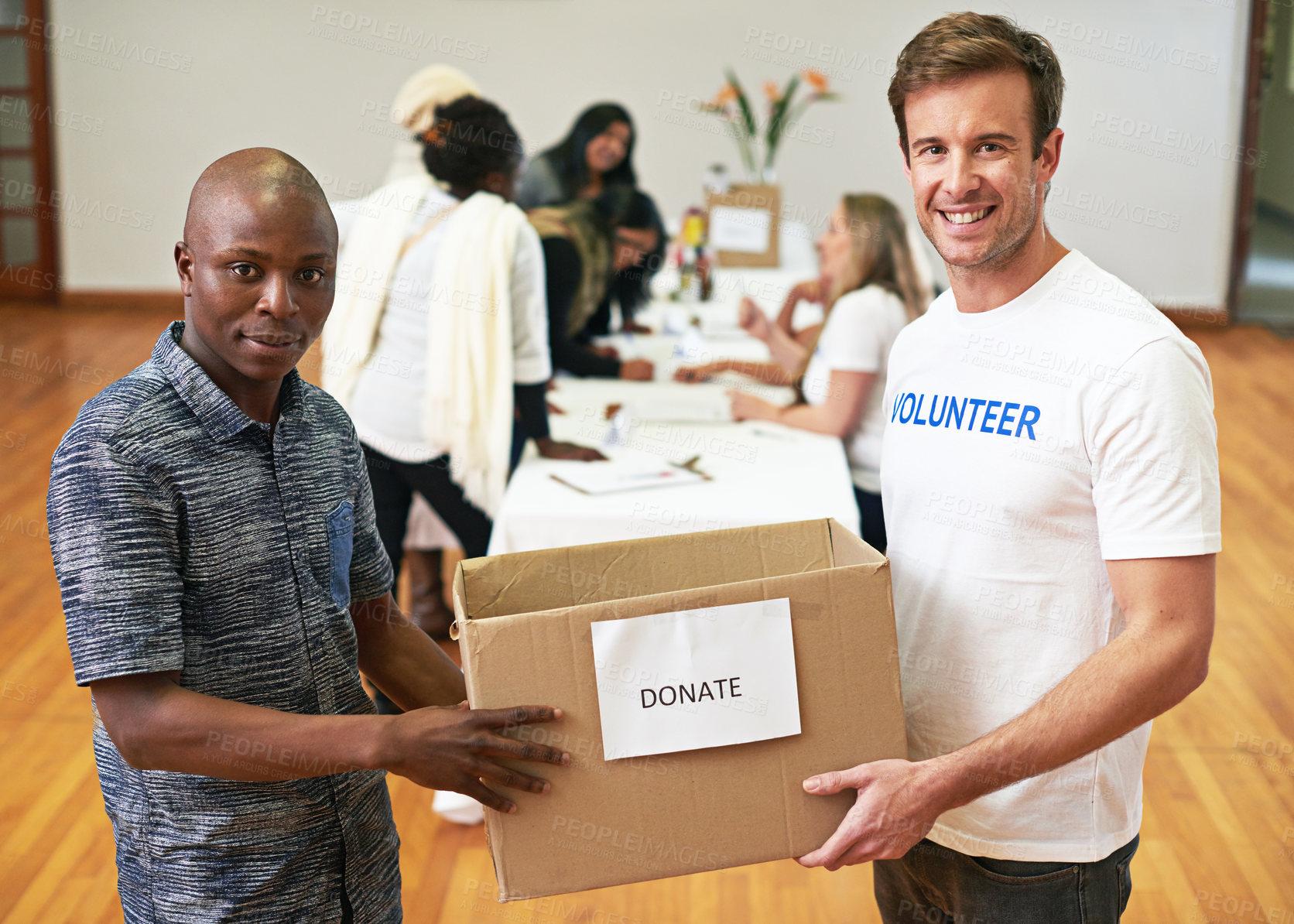 Buy stock photo Cropped portrait of two volunteers carrying a donations box
