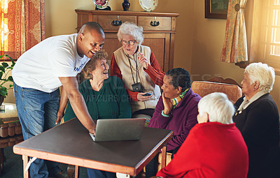 Buy stock photo Shot of a volunteer showing a group of senior women how to use a laptop