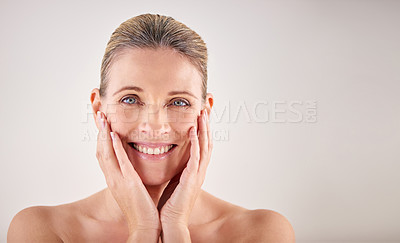 Buy stock photo Cropped studio portrait of an attractive mature woman touching her skin
