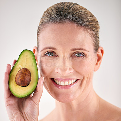 Buy stock photo Skincare, avocado and portrait of mature woman in studio for health, wellness or natural face routine. Smile, beauty and female person with organic fruit for dermatology treatment by white background