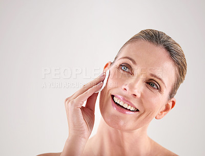 Buy stock photo Mature woman, smile and cotton for skincare in studio with facial cleaning, cosmetics or skin treatment on mockup. Model, person and swab for face detox, makeup removal and beauty on white background