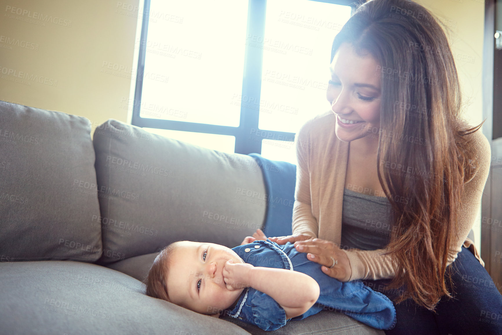 Buy stock photo Shot of a mother dressing her baby girl at home