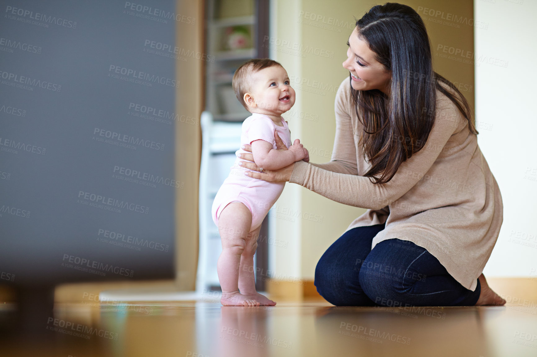 Buy stock photo Shot of a mother helping her baby girl stand