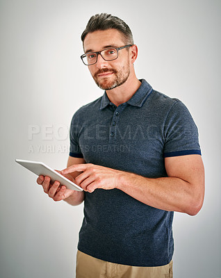 Buy stock photo Shot of a man using a digital tablet against a gray background