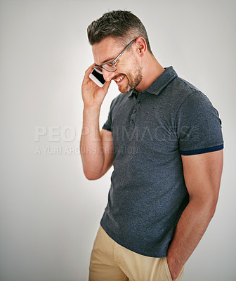 Buy stock photo Shot of a man talking on his cellphone against a gray background