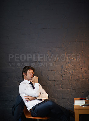 Buy stock photo Shot of a businessman looking thoughtful while sitting in his office late at night