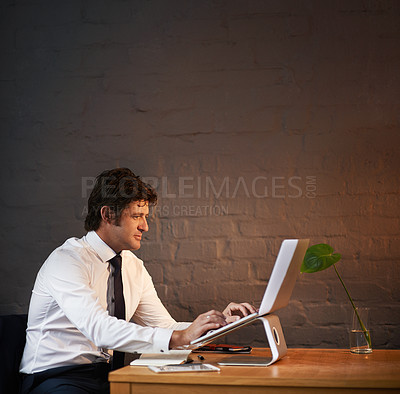 Buy stock photo Shot of a businessman working on his laptop after hours