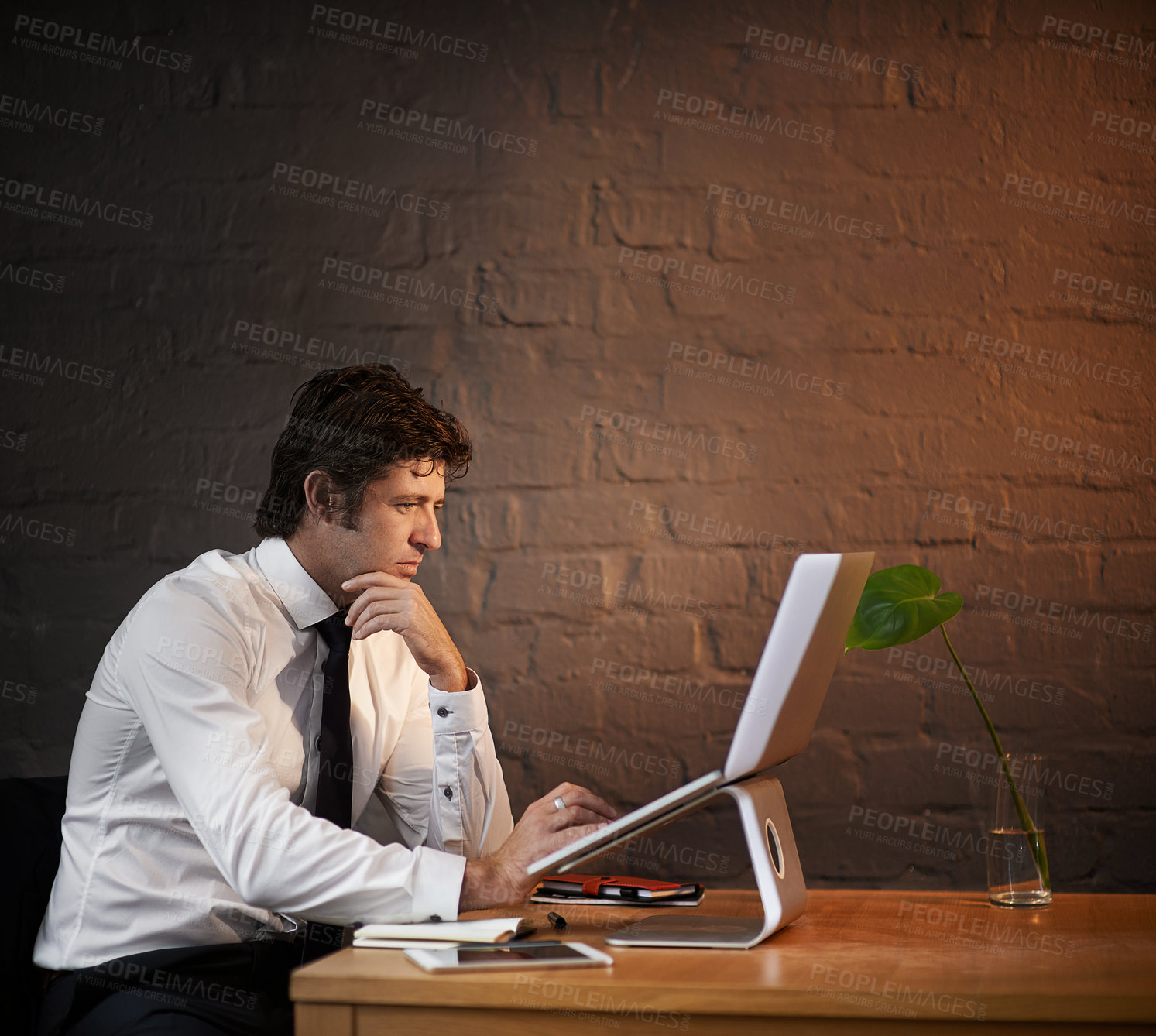 Buy stock photo Shot of a businessman working on his laptop after hours