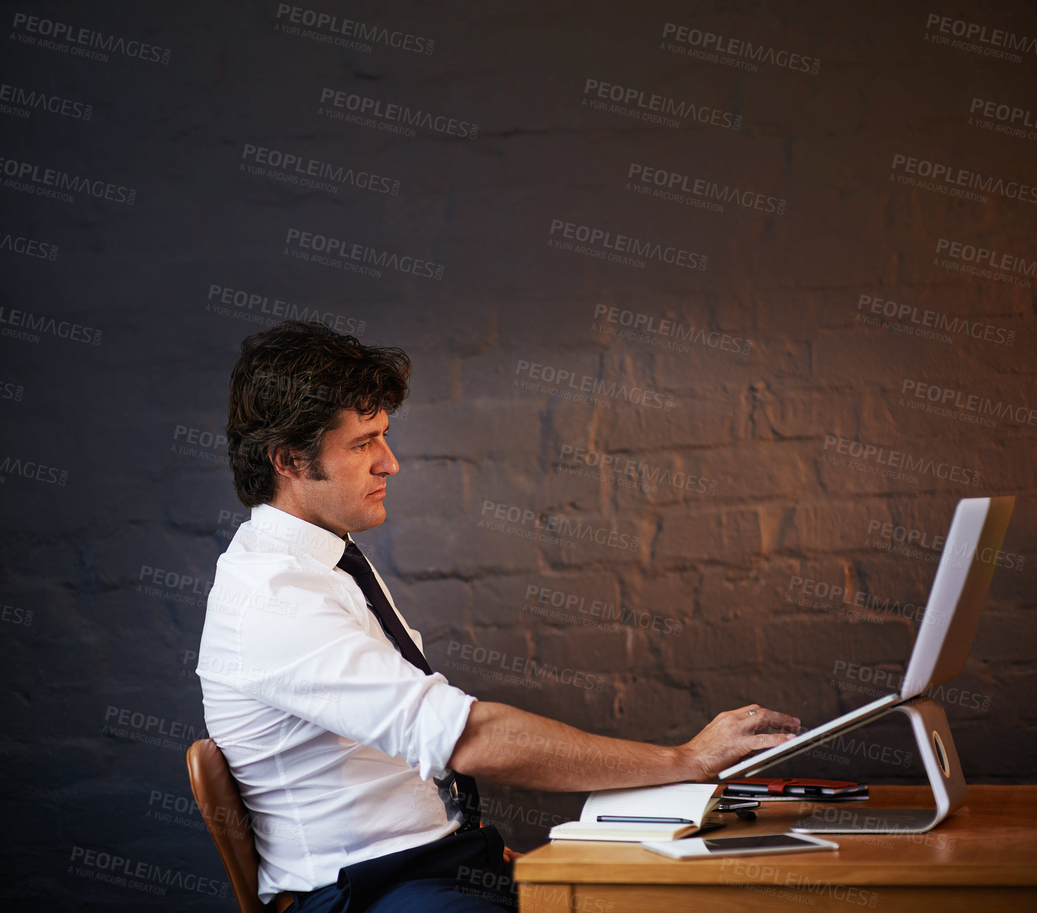 Buy stock photo Shot of a businessman working late at the office