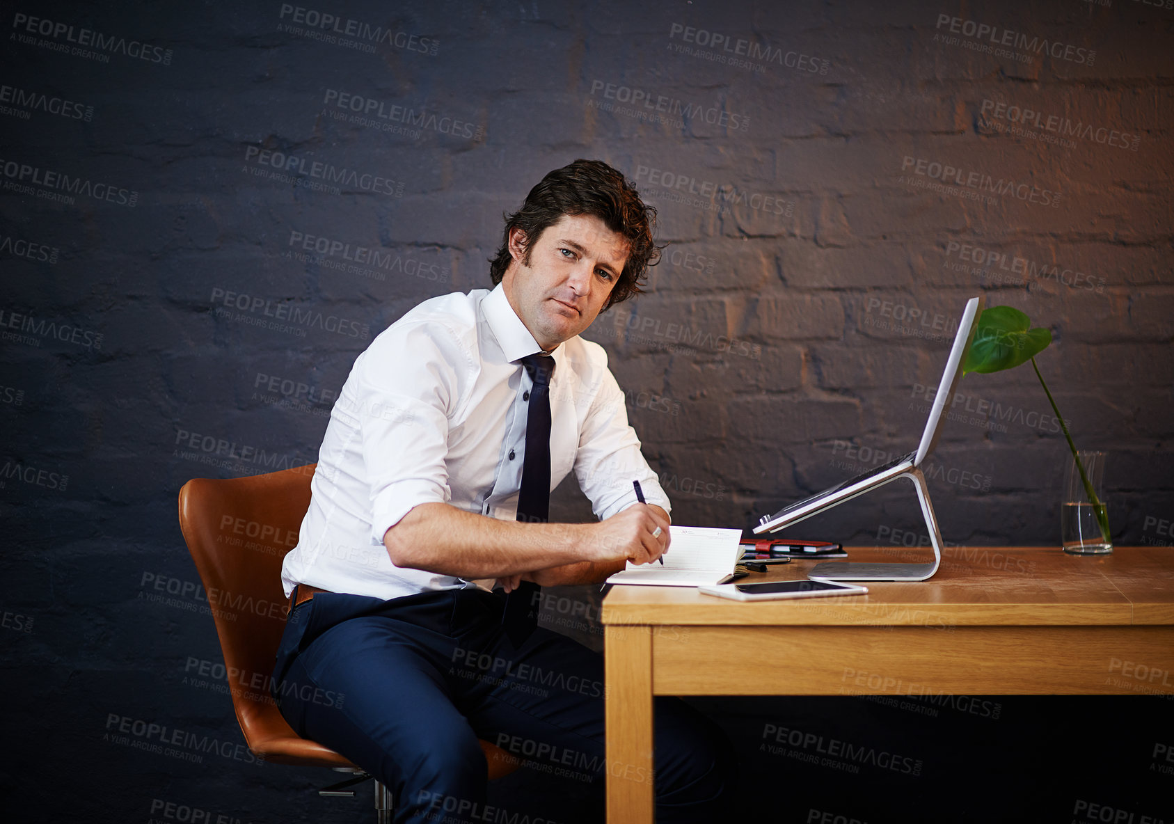 Buy stock photo Investigation, portrait and writing with detective man in office at night to work on criminal report. Desk, laptop and notebook with mature investigator on brick wall for evidence or justice