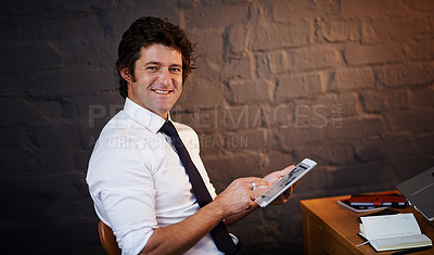 Buy stock photo Shot of a businessman using a digital tablet in the office
