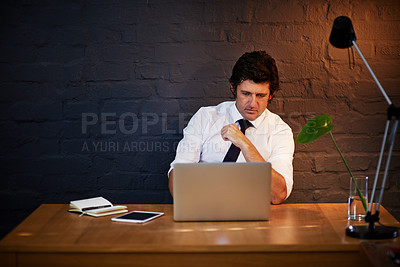 Buy stock photo Shot of a businessman working on his laptop late at night